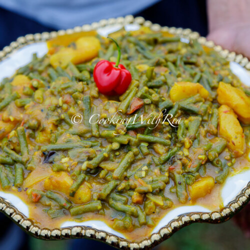 Curry Bodi and Aloo in a serving platter — tender long beans and potatoes coated in a rich Trinidad curry with green seasoning and thyme.