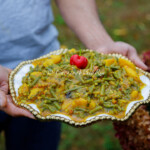 Curry Bodi and Aloo in a serving platter — tender long beans and potatoes coated in a rich Trinidad curry with green seasoning and thyme.