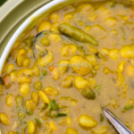 Instant Pot Curry Lima Beans (Caribbean Style) served in a white bowl, garnished with fresh thyme