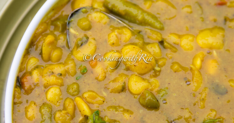 Instant Pot Curry Lima Beans (Caribbean Style) served in a white bowl, garnished with fresh thyme